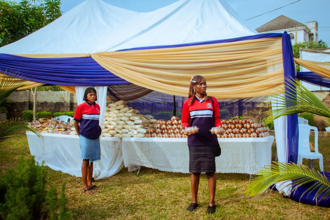 Tables of rice, eggs and food supplies laid out under a canopy before distribution