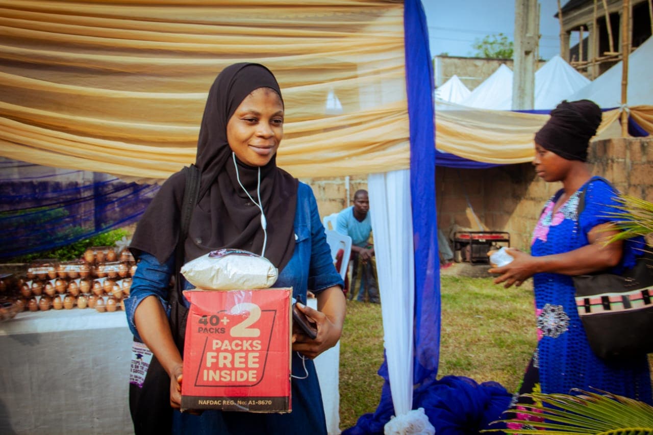 A woman carrying food supplies received at a Foundation outreach
