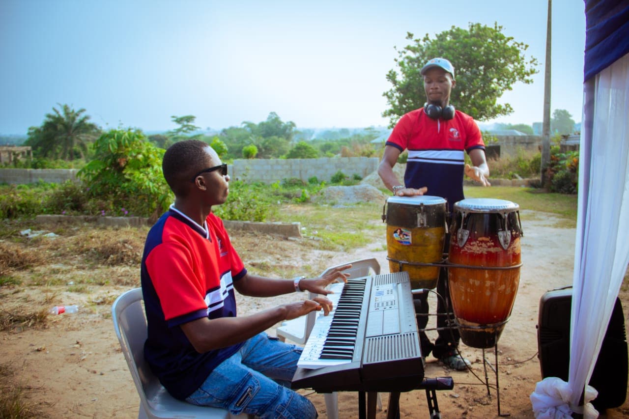 Two musicians playing keyboard and conga drums outdoors at a Foundation outreach